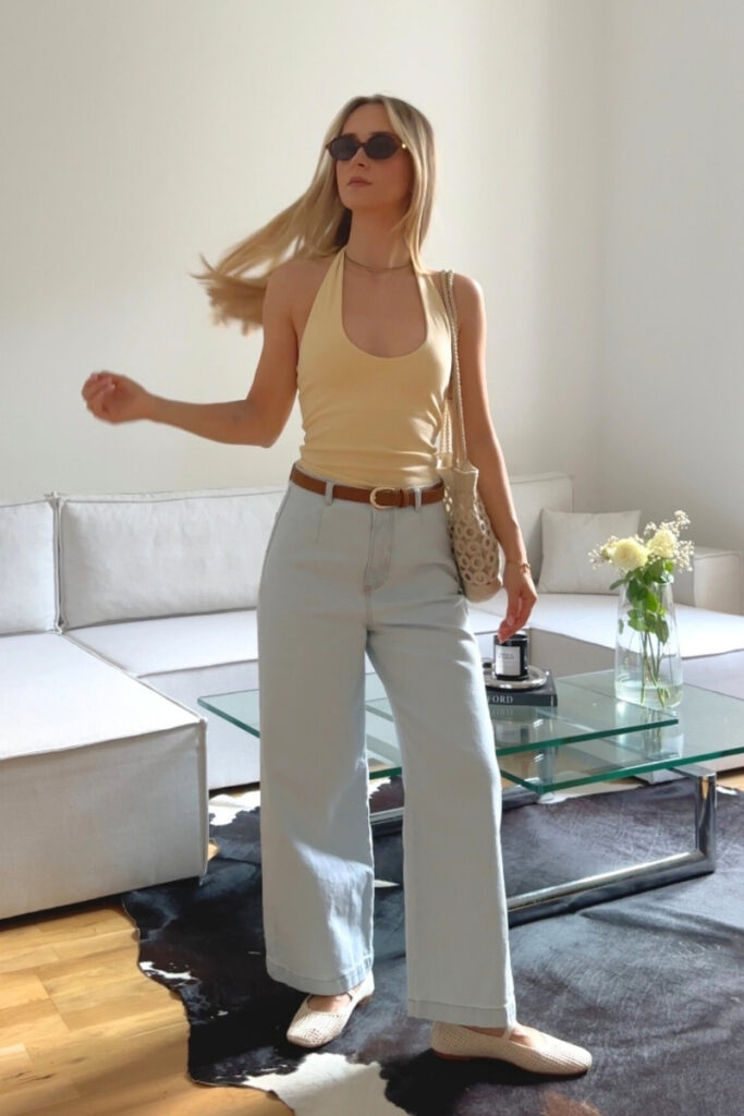 Blong girl posing in a butter yellow top and jeans